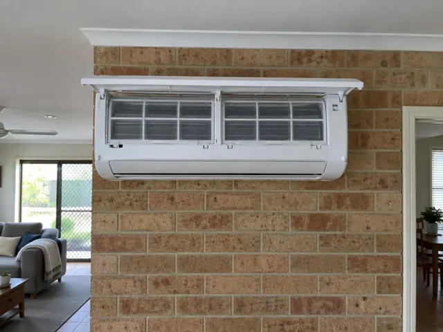 Clean split system indoor unit with open front panel and visible filters on a brick wall in Burleigh Waters