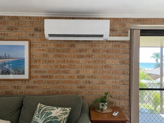 Running split system on a brick living room wall above a sofa in Mermaid Beach